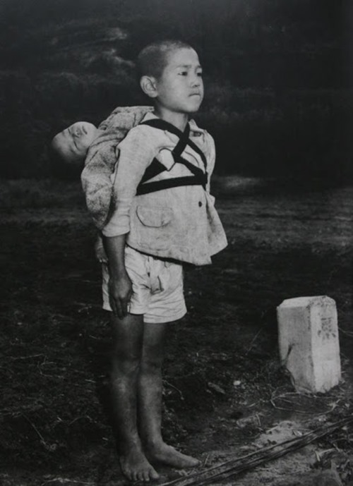 Menino carregando seu irmão morto, provavelmente vítima de radiação, em Nagasaki, em 1945.