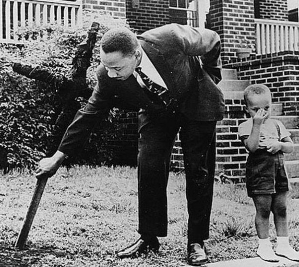 Martin Luther King y su hijo removiendo una cruz quemada que miembros del KKK dejaron frente a su casa en 1960.