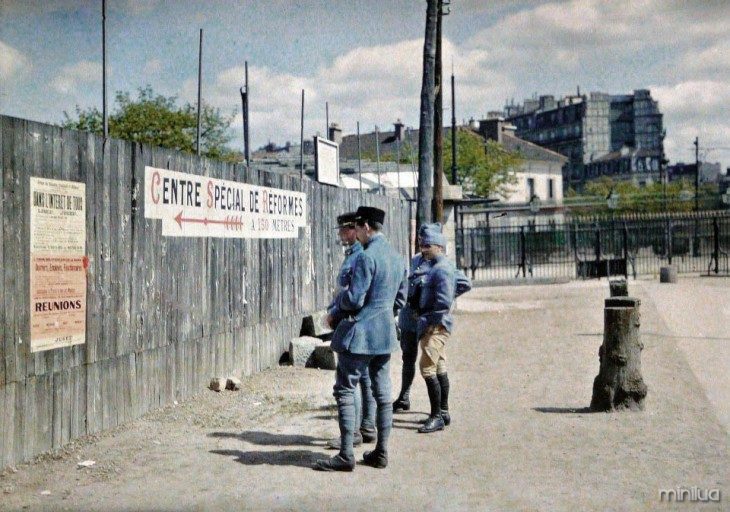 Paris soldados lendo um cartaz na parede 