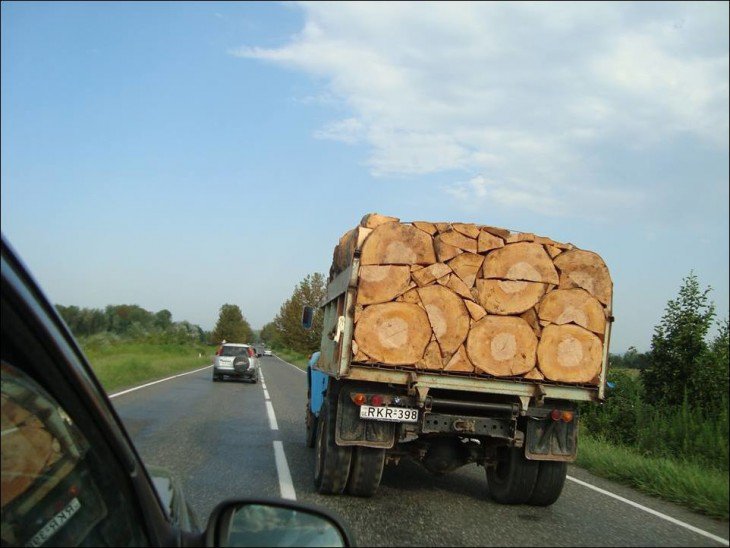 Caminhão em uma estrada com pedaços de madeira em perfeita ordem 