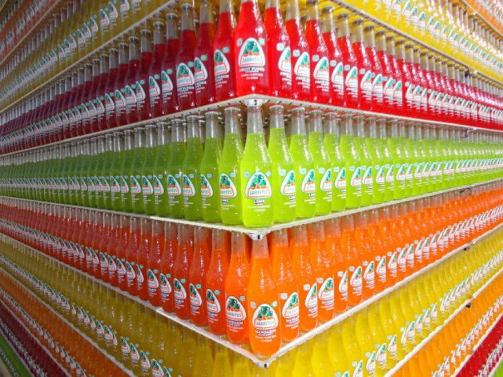 garrafas de vidro Jarritos acomodados por cores e sabores 