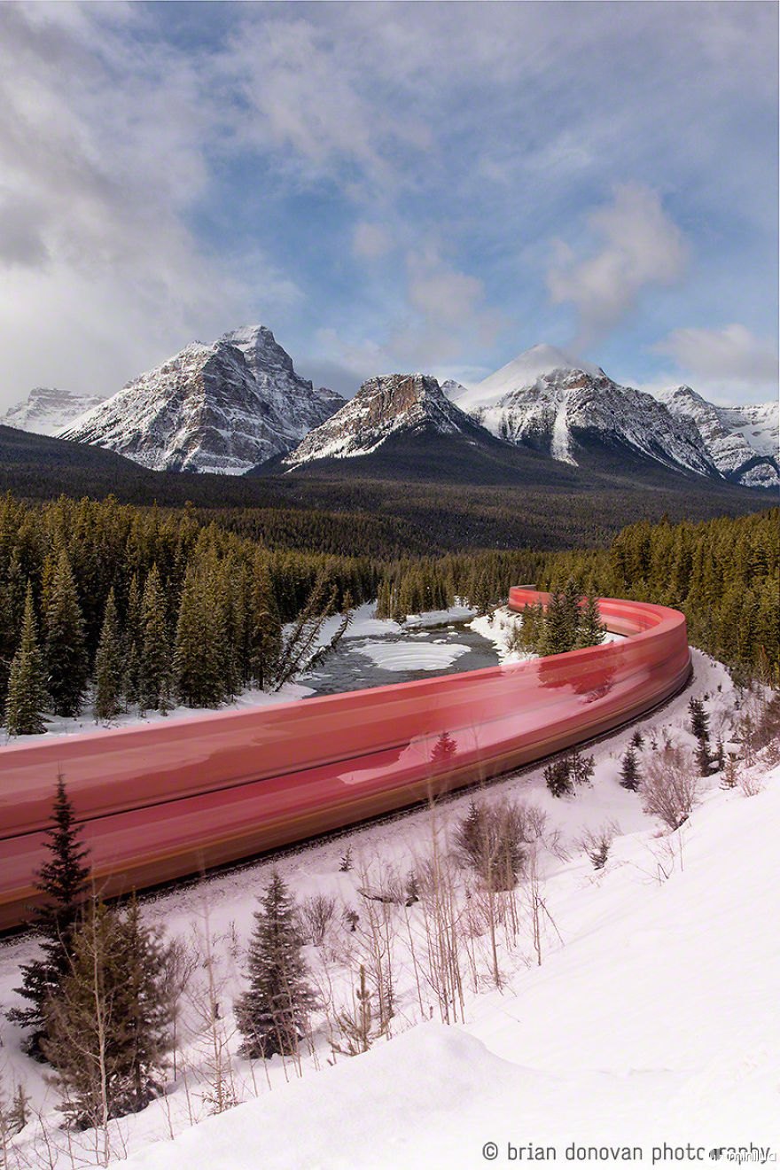 Uma foto de exposição prolongada de um trem que ruge através das Montanhas Rochosas canadenses