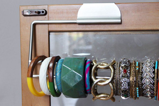pulseiras organizador por trás de uma porta do armário com um rolo de papel toalha 