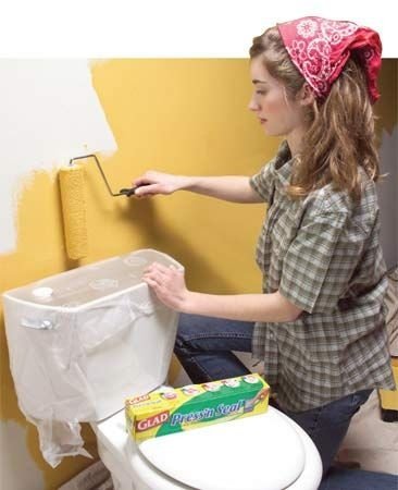 ajoelhado mulher pintando uma parede amarela 