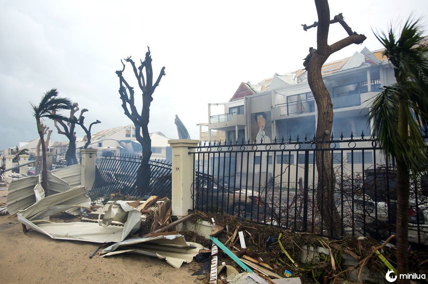 A fumaça sobe de um fogo entre detritos e edifícios danificados em Marigot, perto da baía de urtiga, na ilha francesa de santo martin na quarta-feira