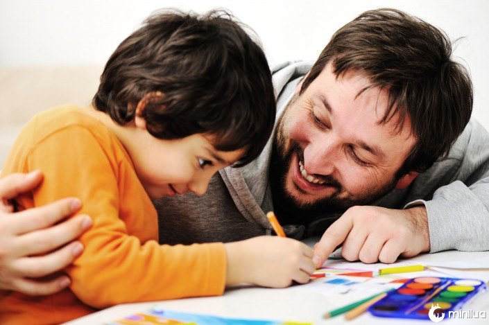 Father and little boy of fivr years having fun painting at home