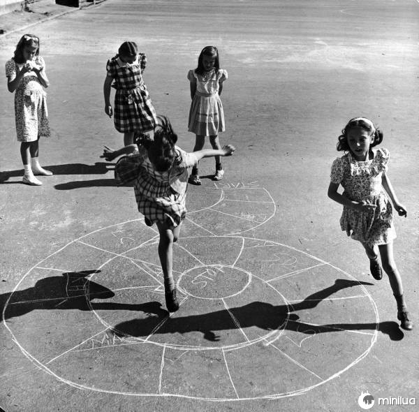 meninas jogando em uma rua em um pequeno avião no chão 