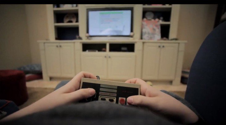 Mãos de uma pessoa jogando Nintendo em uma sala 