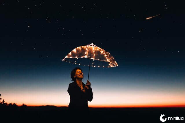 Mulher segurando guarda-chuva iluminado