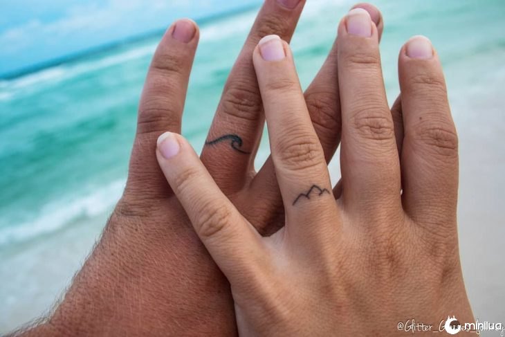dos manos con anillos tatuados 