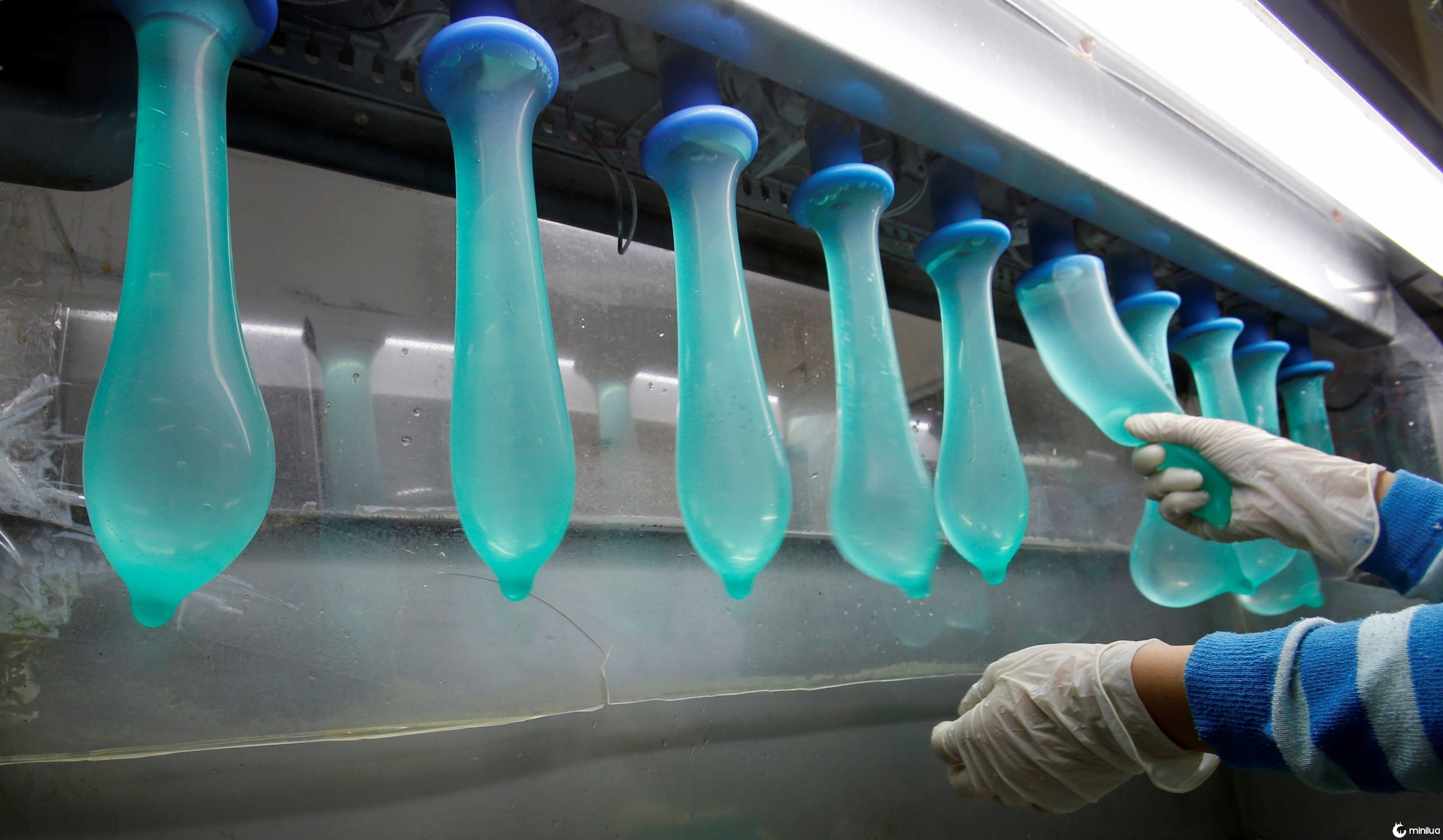 A worker performs a test on condoms at Malaysia's Karex condom factory in Pontian