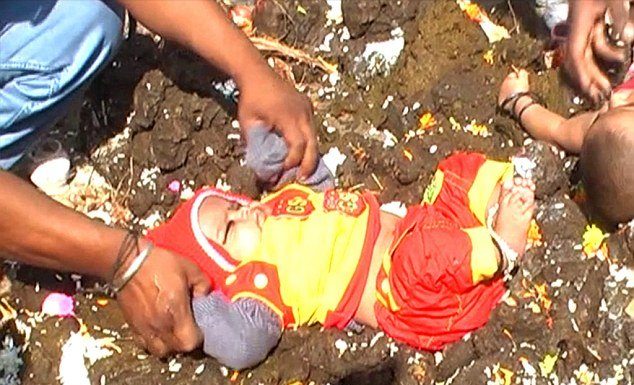 Crianças indianas roladas no cocô de vaca para dar sorte