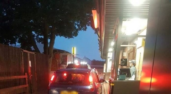 Duas crianças passam pelo McDonald's Drive-Thru em carros de brinquedo Little Tykes