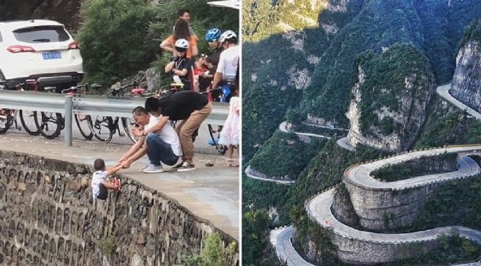 Momento tenso, pai balança criança sobre a borda do penhasco para posar para fotos