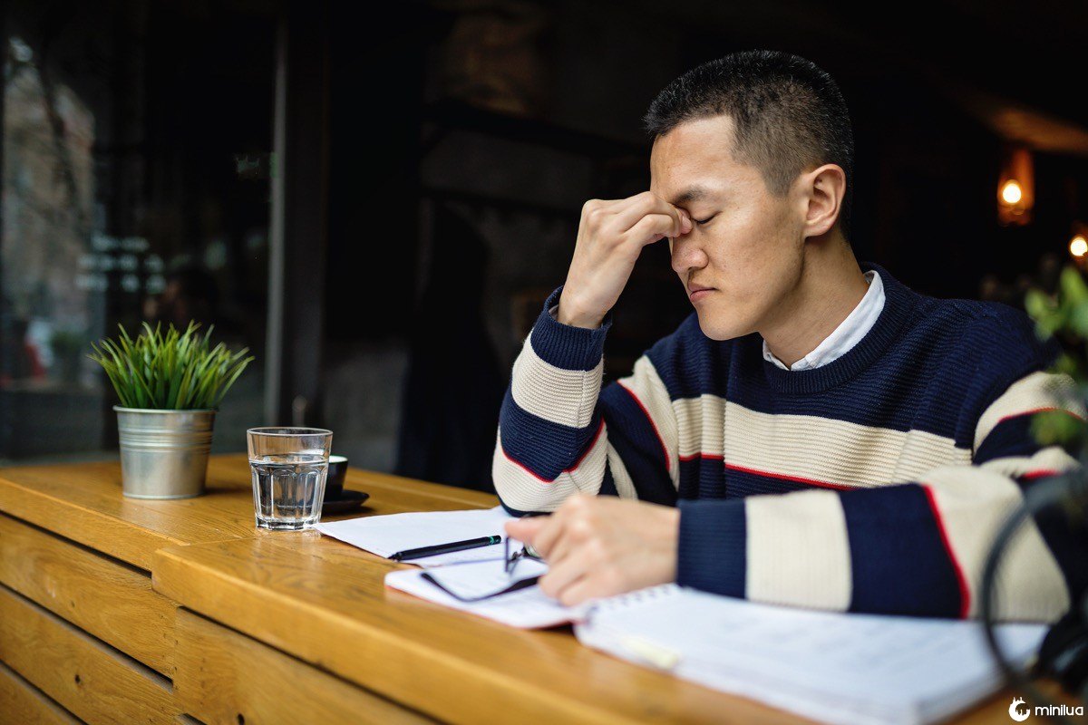 Succesful young japanese freelance worker organizing his time while sitting in a cafe