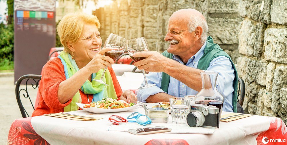 elderly couple drinks wine and eats in Italy