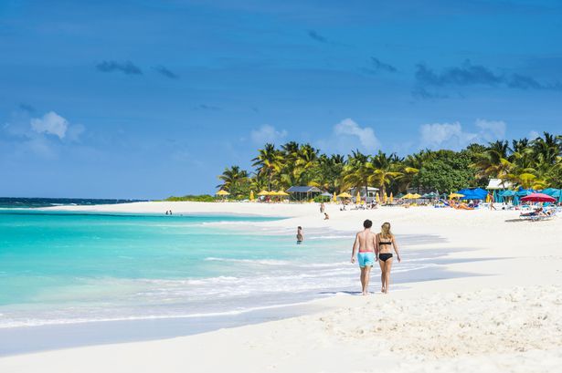 Casal caminha na praia de Shoal Bay East, na ilha caribenha de Anguilla