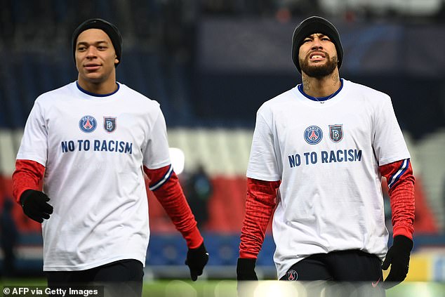 Kylian Mbappe (L) e Neymar (R) usam camisetas "Não ao Racismo" enquanto se aquecem para o jogo